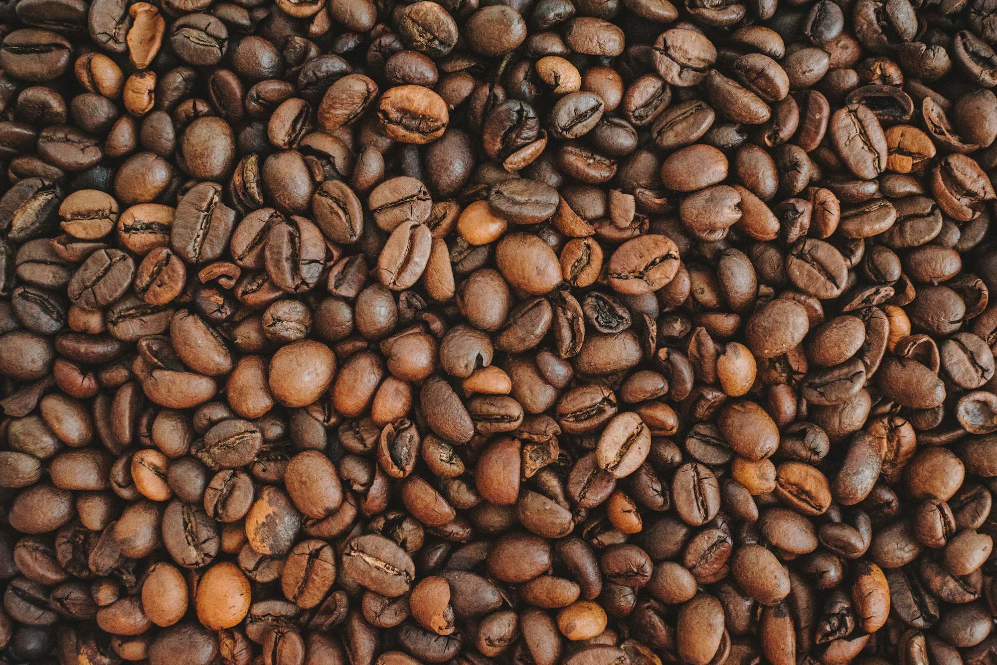 Granos de café tostado sobre una mesa de madera