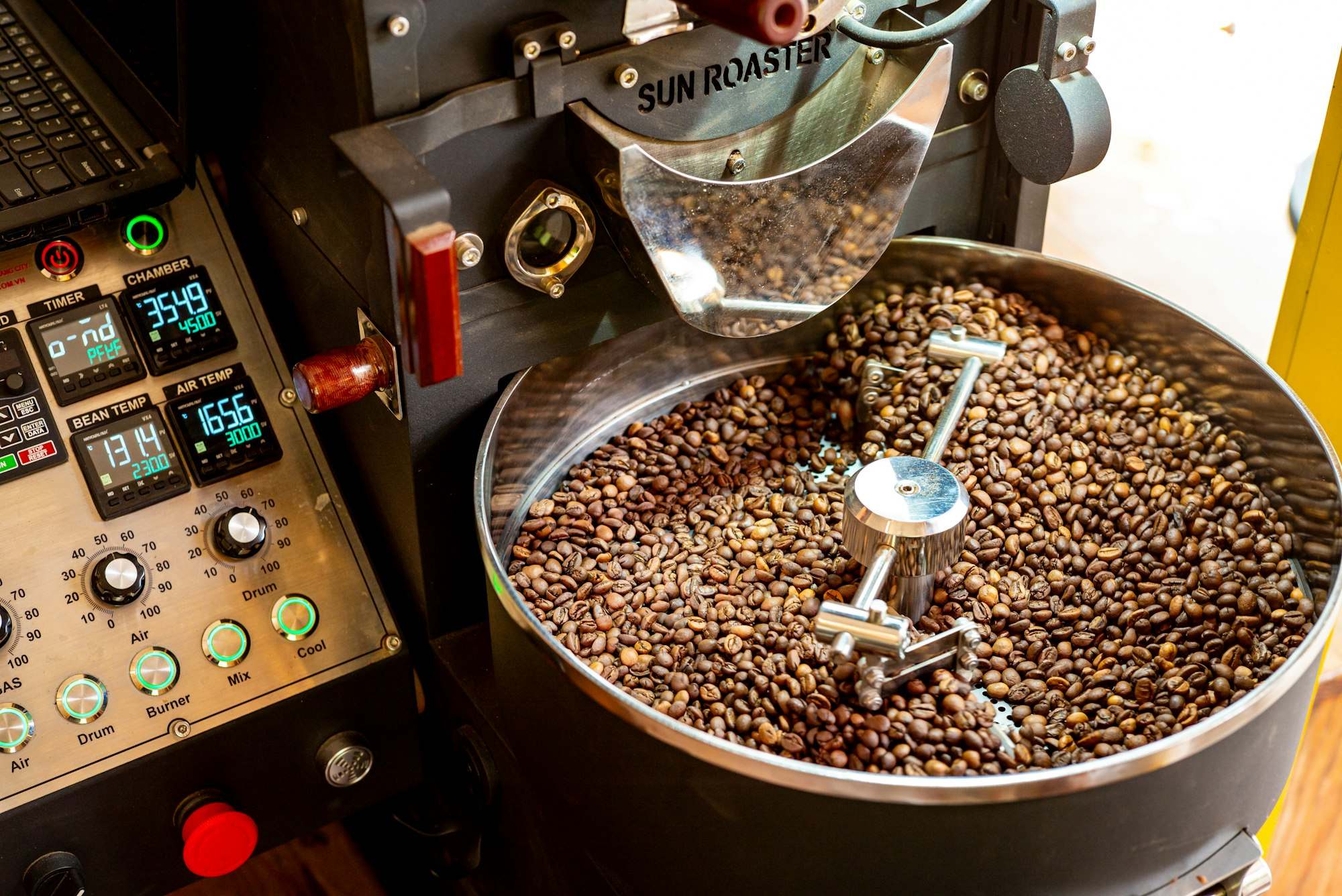 Granos de café girando en la bandeja de enfriamiento del tostador